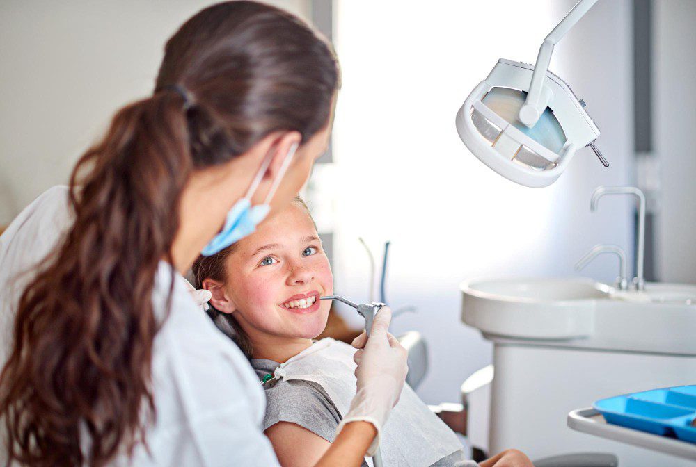 A dentist with a smiling young patient for a blog on dental anxiety in children